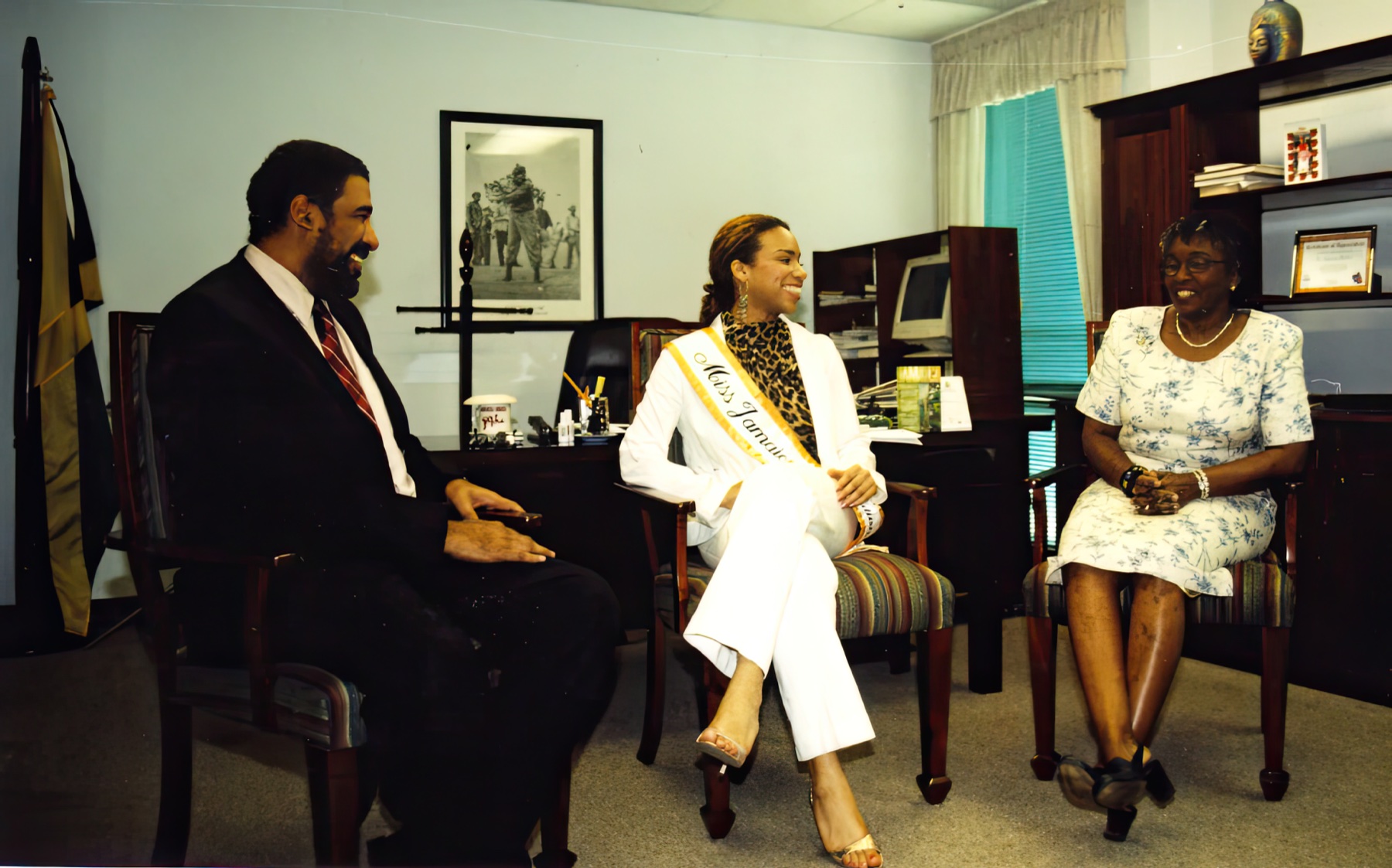 Daisi in her Miss Jamaica International sash, seated with Jamaica Tourist Board representatives.