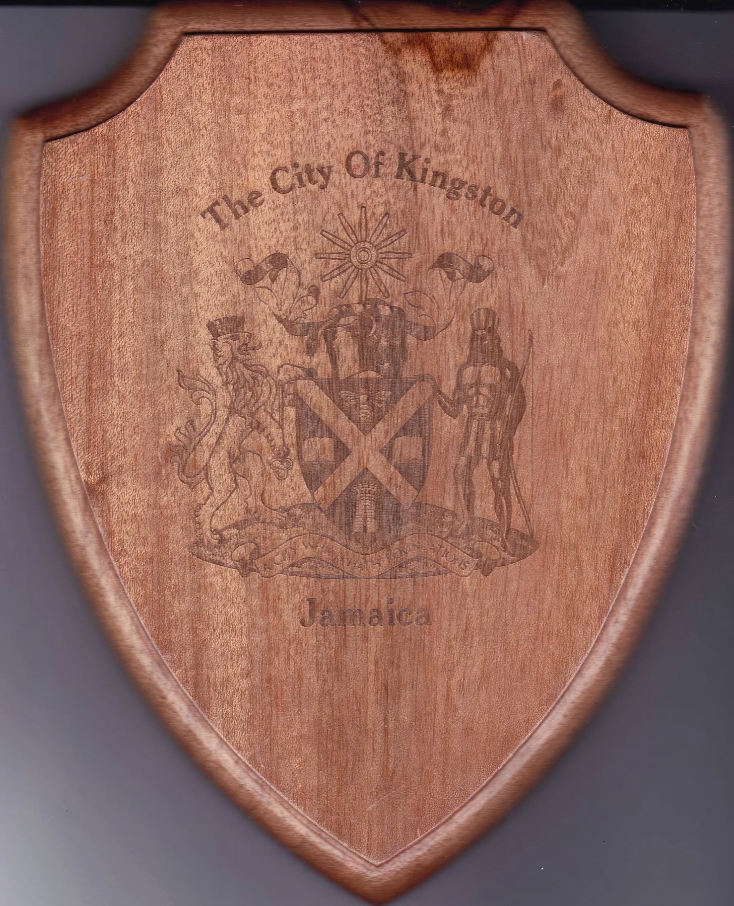 Wooden shield-shaped plaque engraved with the City of Kingston crest and Jamaica.