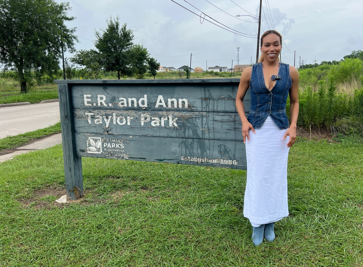 Daisi Pollard Sepulveda beside the E.R. and Ann Taylor Park sign.